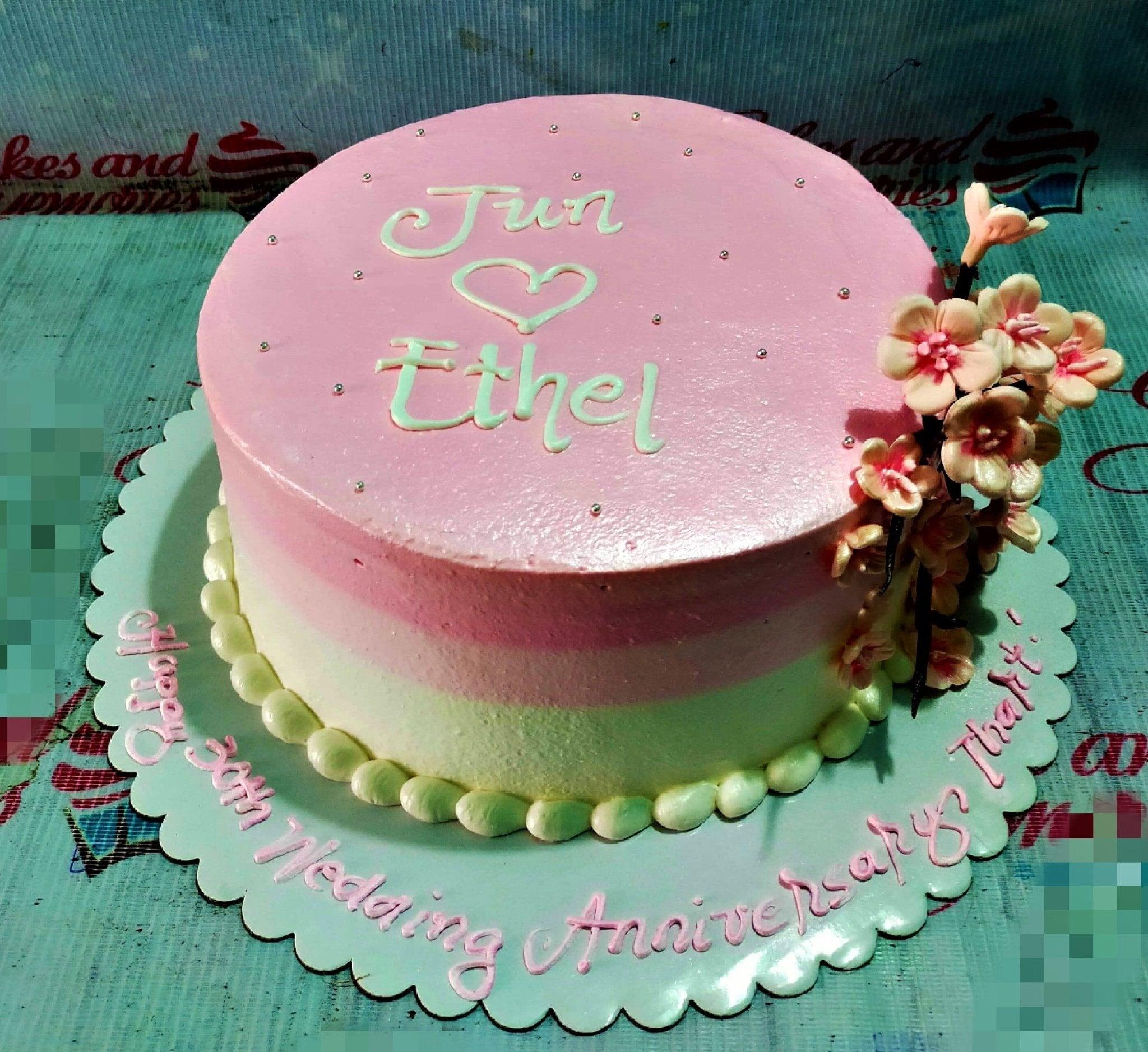 Pink and white gradient anniversary cake with cherry blossom flowers and silver dragees.