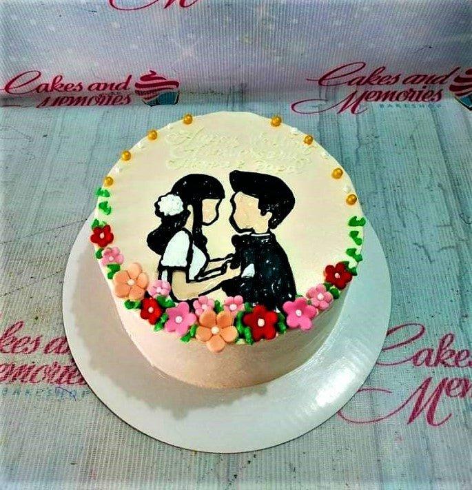 White minimalist anniversary cake featuring a hand-painted black and white couple silhouette surrounded by colorful fondant flowers and gold pearls.