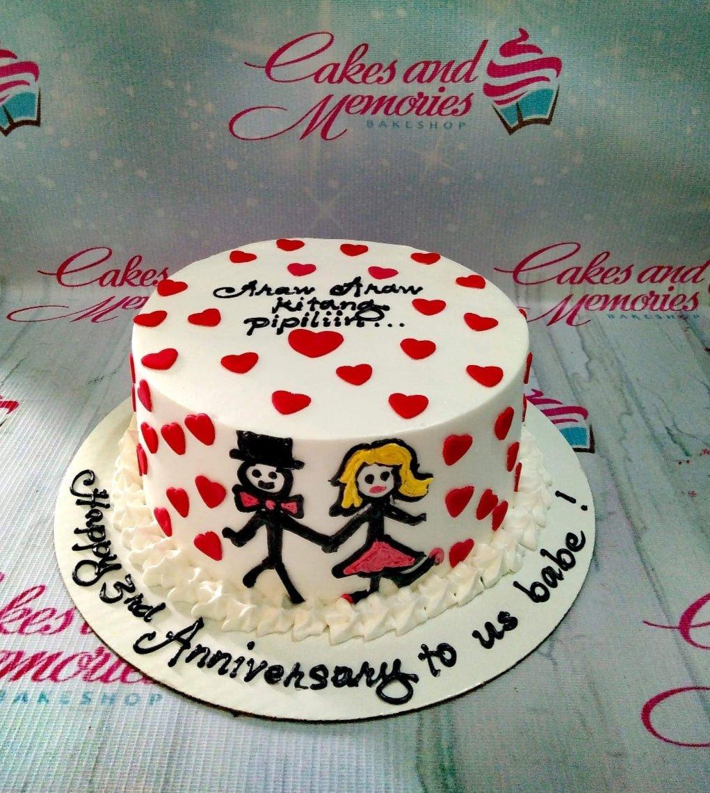 White minimalist anniversary cake with red heart decorations and hand-drawn stick figure couple holding hands.