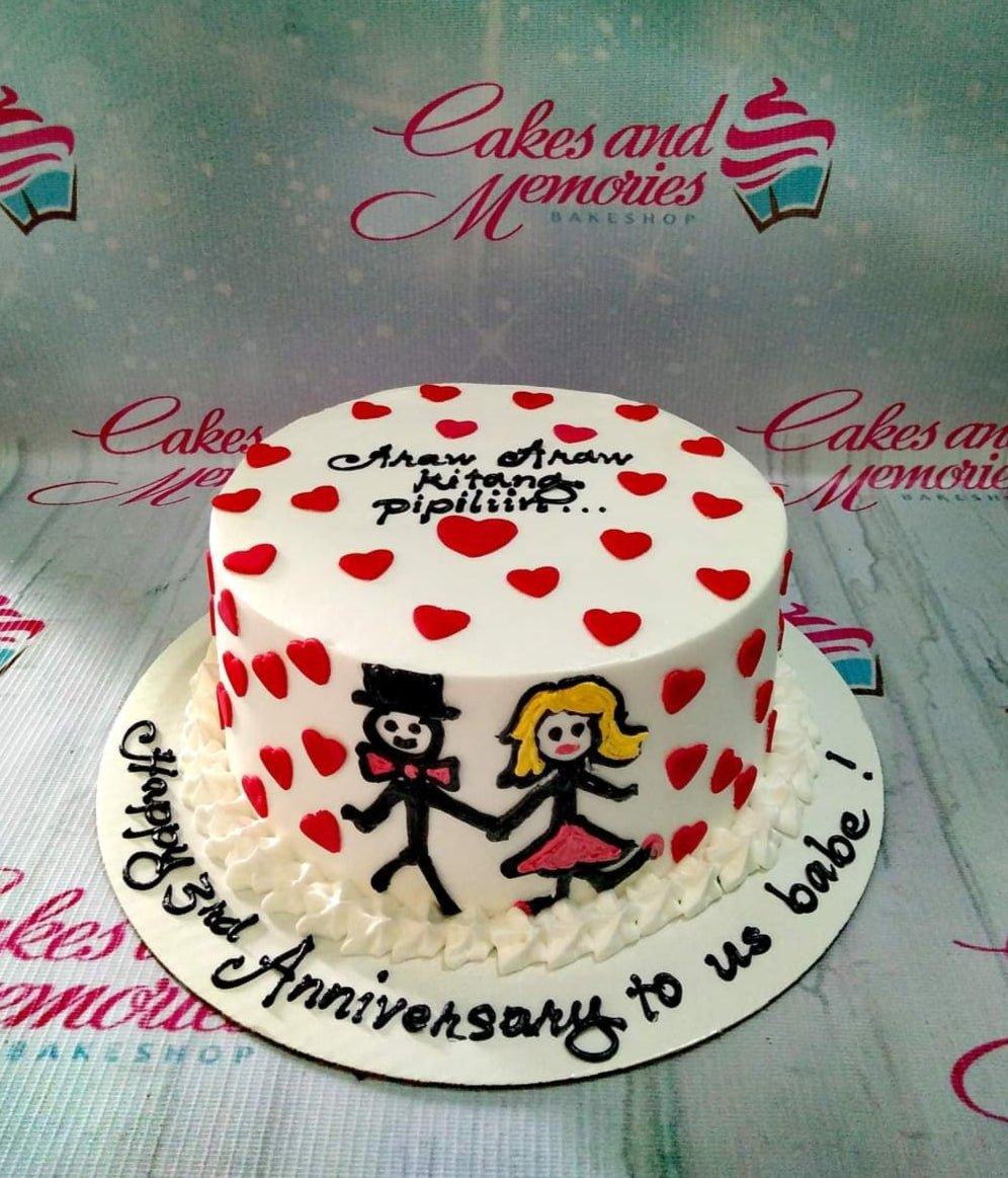 White minimalist anniversary cake with red hearts and hand-drawn stick figure couple holding hands.