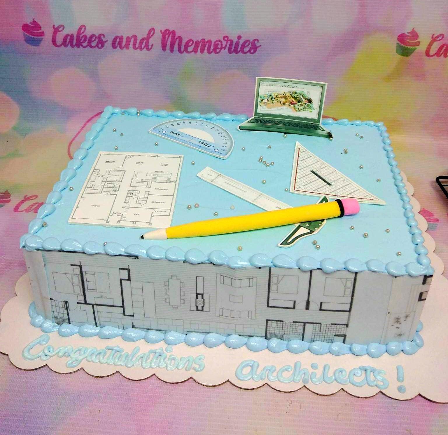 Light blue square architect themed cake with printed floor plans, protractor, ruler, and a yellow fondant pencil topper.