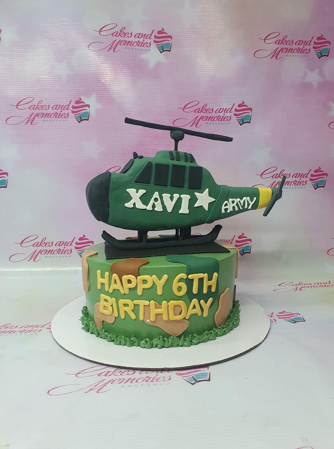Green camouflage army themed cake with a large 3D fondant helicopter topper and yellow birthday message.