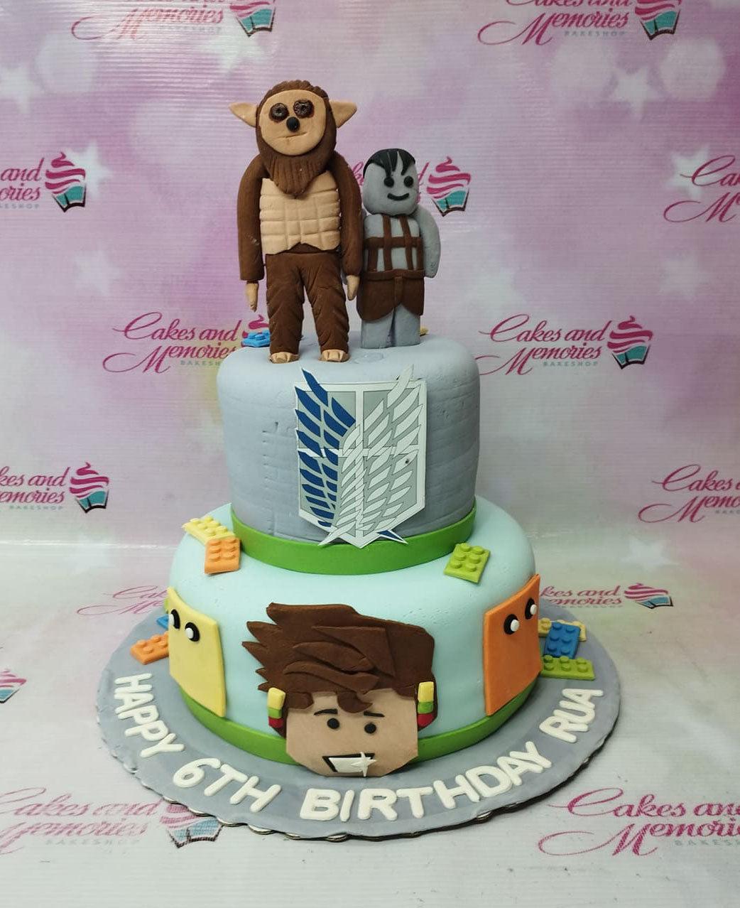 Two-tier Attack on Titan and Roblox themed cake with fondant figures of Beast Titan and a Roblox character on top.