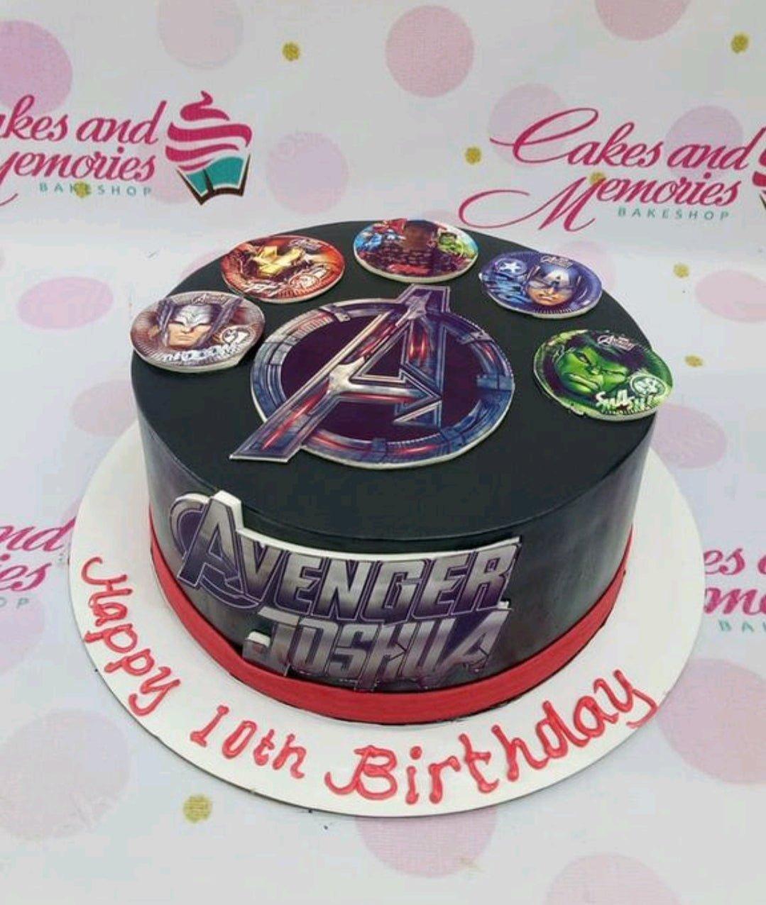 Black Avengers themed birthday cake with character printouts and a red ribbon border on a white base board.
