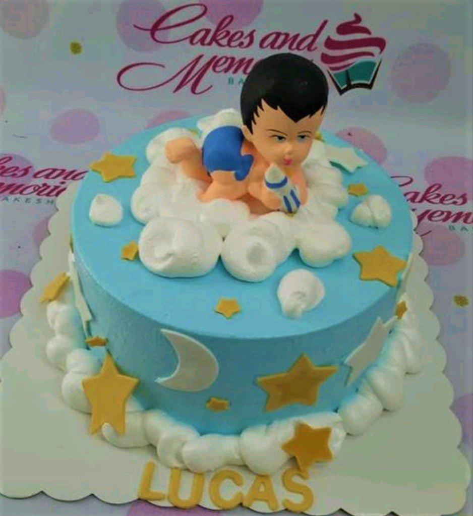 Light blue baby boy birthday cake with a 3D baby figurine, white fondant clouds, and yellow stars.