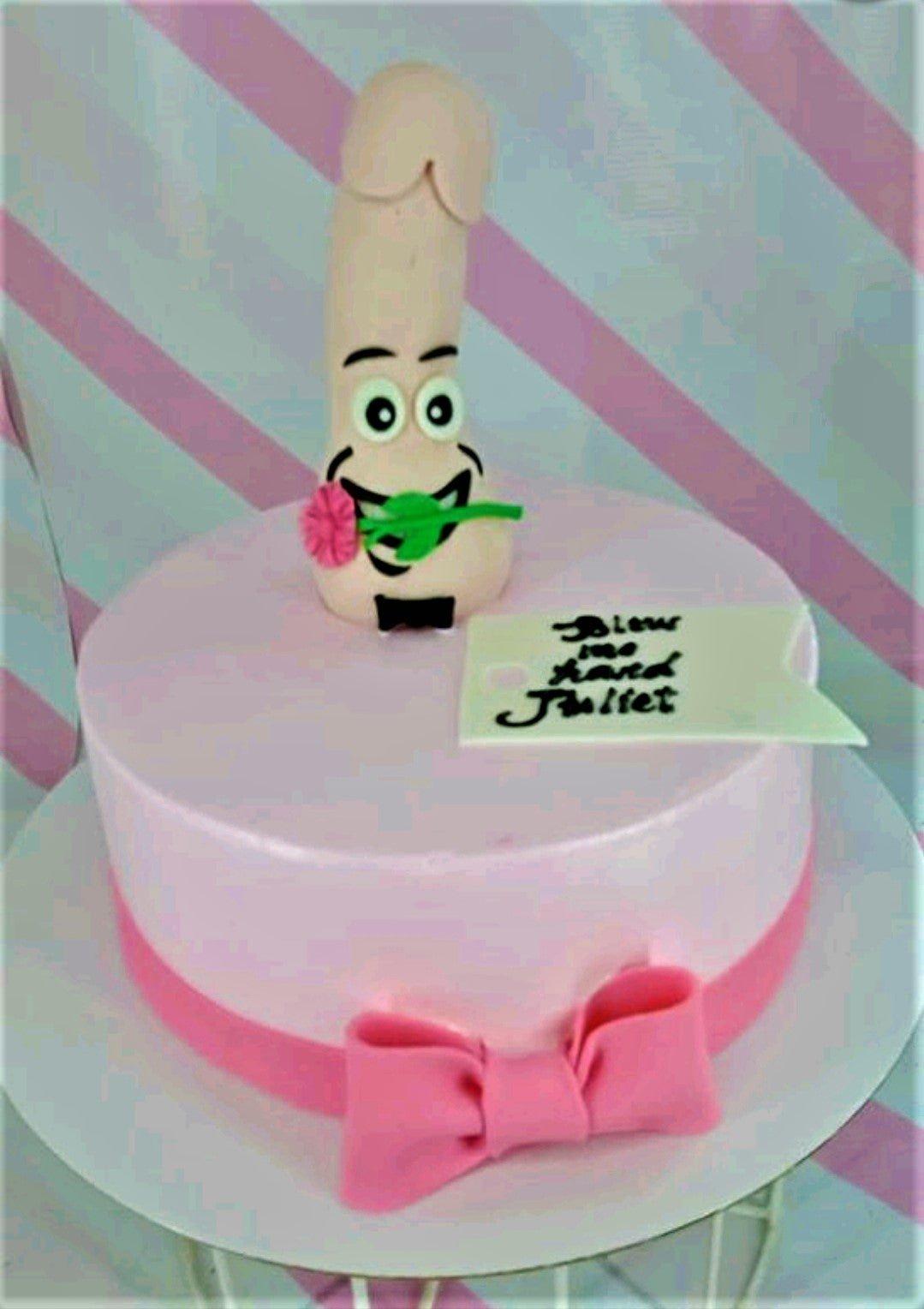 Pink bachelorette cake featuring a humorous 3D fondant figure with a face and a pink bow at the base.