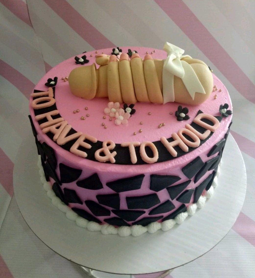 Pink bachelorette cake with a humorous hand-shaped fondant topper and black geometric patterns on the side.