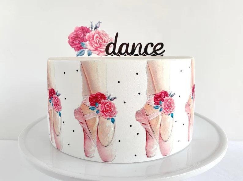 White minimalist cake with watercolor ballerina slippers and floral print wrap, topped with a black dance topper.