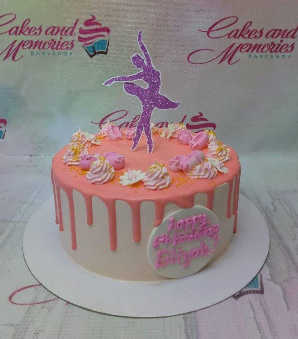 Pink ballerina birthday cake with pink icing drips, piped rosettes, and a purple glitter ballerina topper.