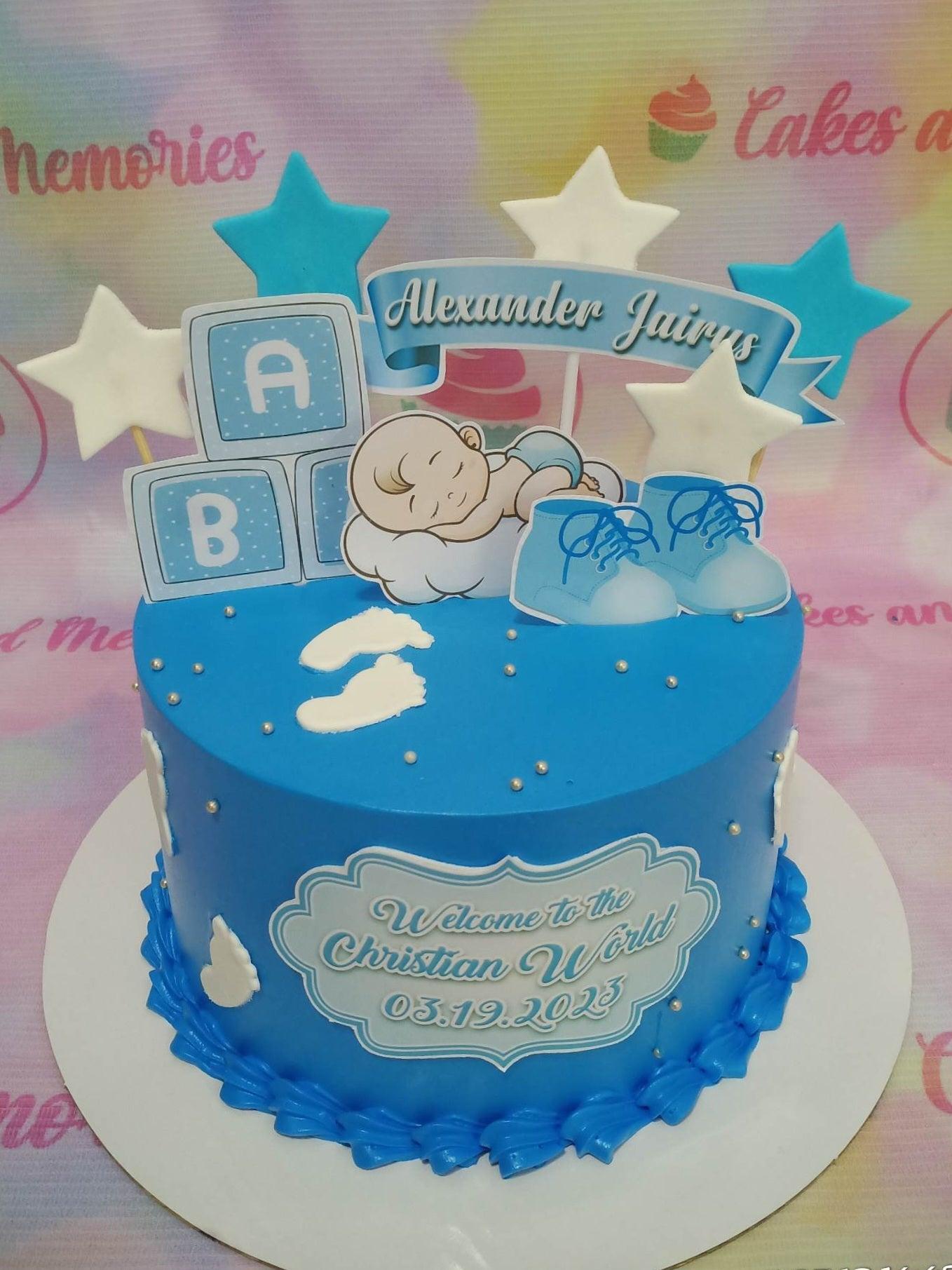 Blue Christian World baptism cake with sleeping baby, baby shoes, and star toppers.