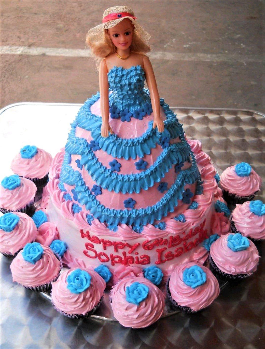 Pink and blue Barbie doll dress cake with ruffled icing and matching cupcakes