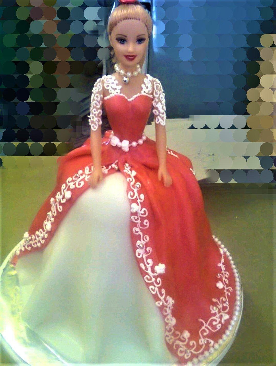 Barbie doll cake with a large red and white fondant ballgown dress featuring intricate white icing embroidery and pearl accents.