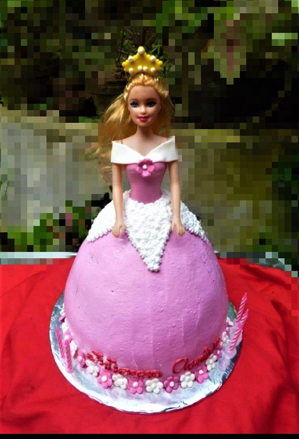 Barbie doll princess cake with a pink dome-shaped skirt icing, white bodice details, and a yellow crown topper.
