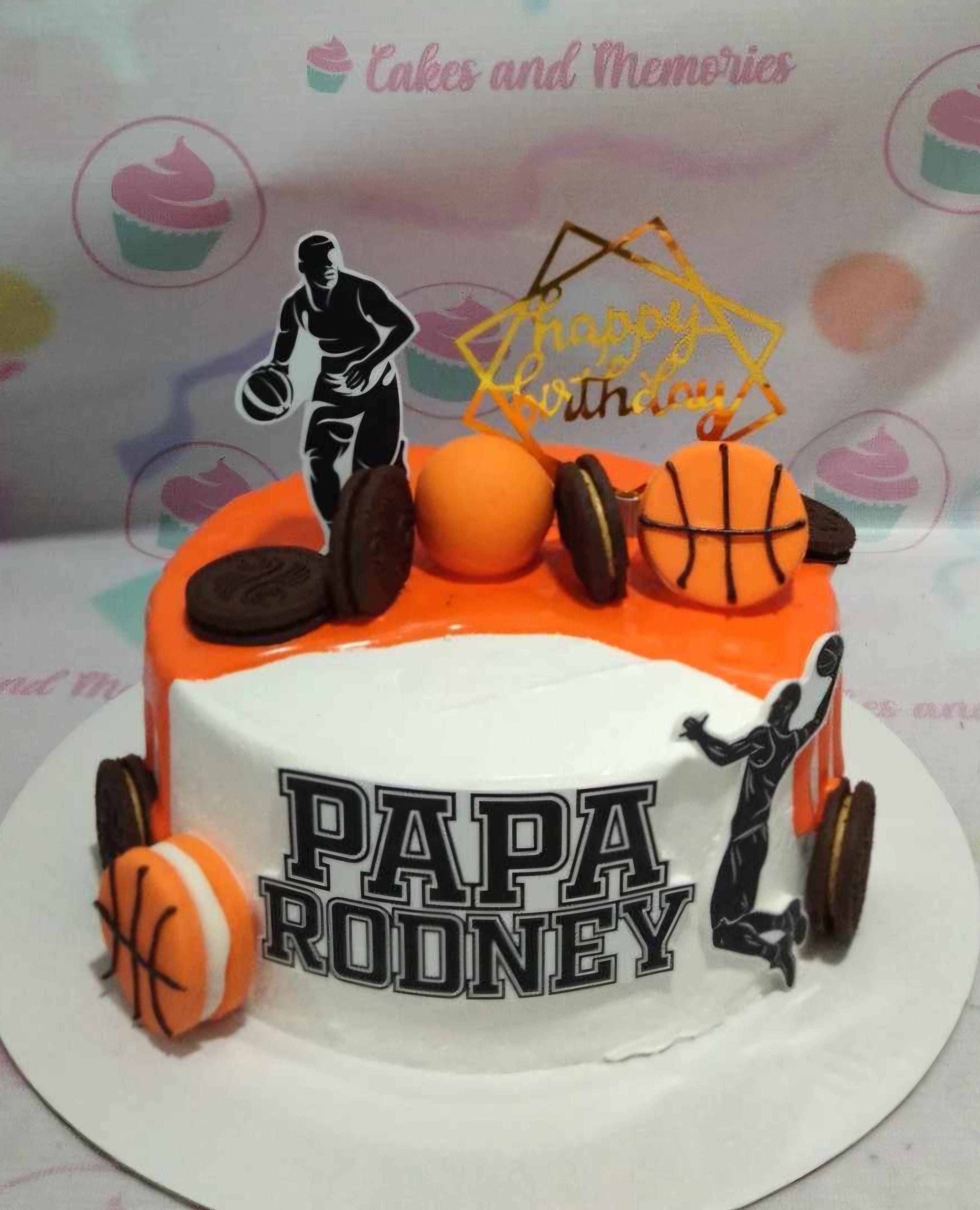 Basketball themed birthday cake with orange drip icing, Oreo cookies, basketball toppers, and a black silhouette of a player.