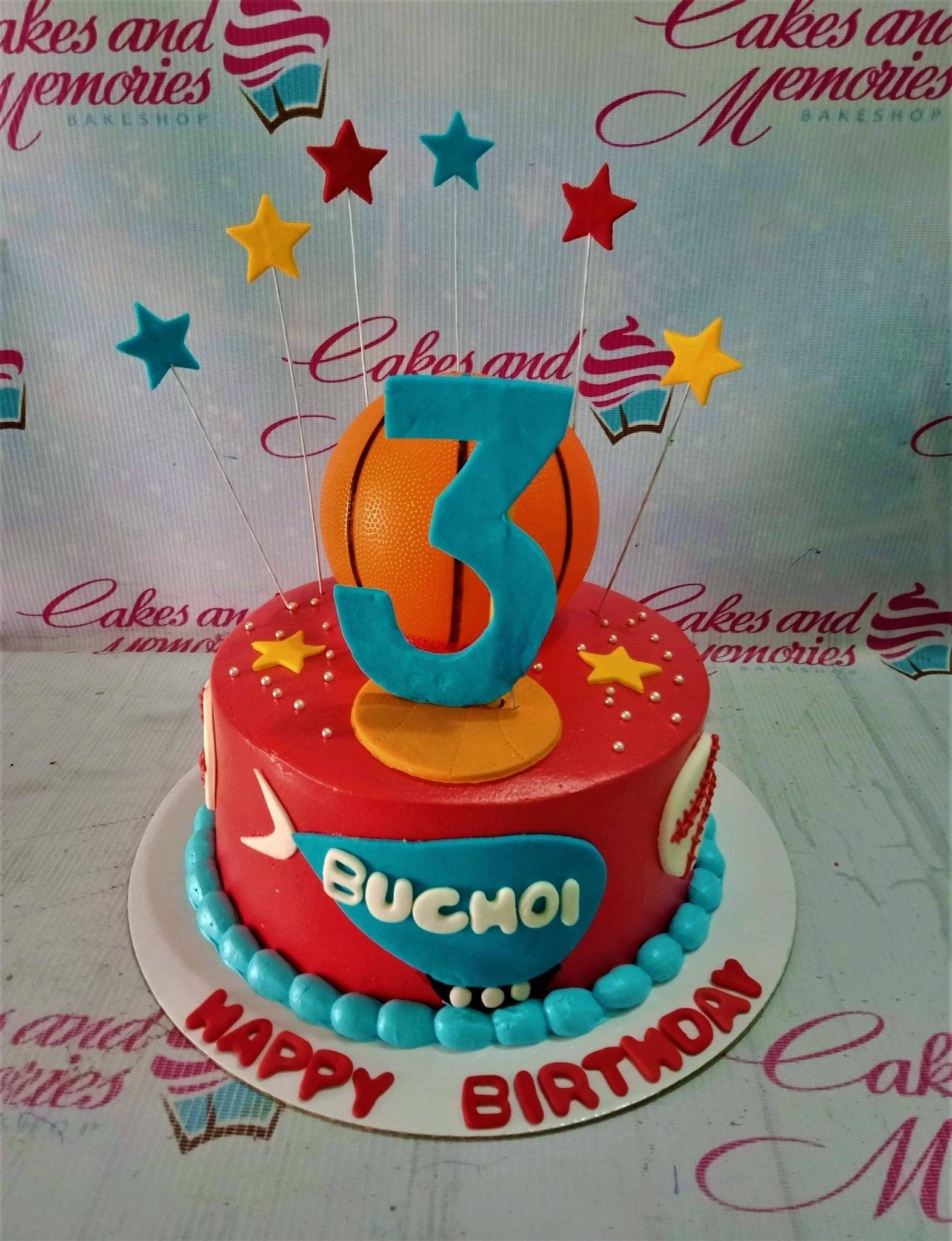Red basketball and sports themed birthday cake with a large blue number 3 and star toppers.