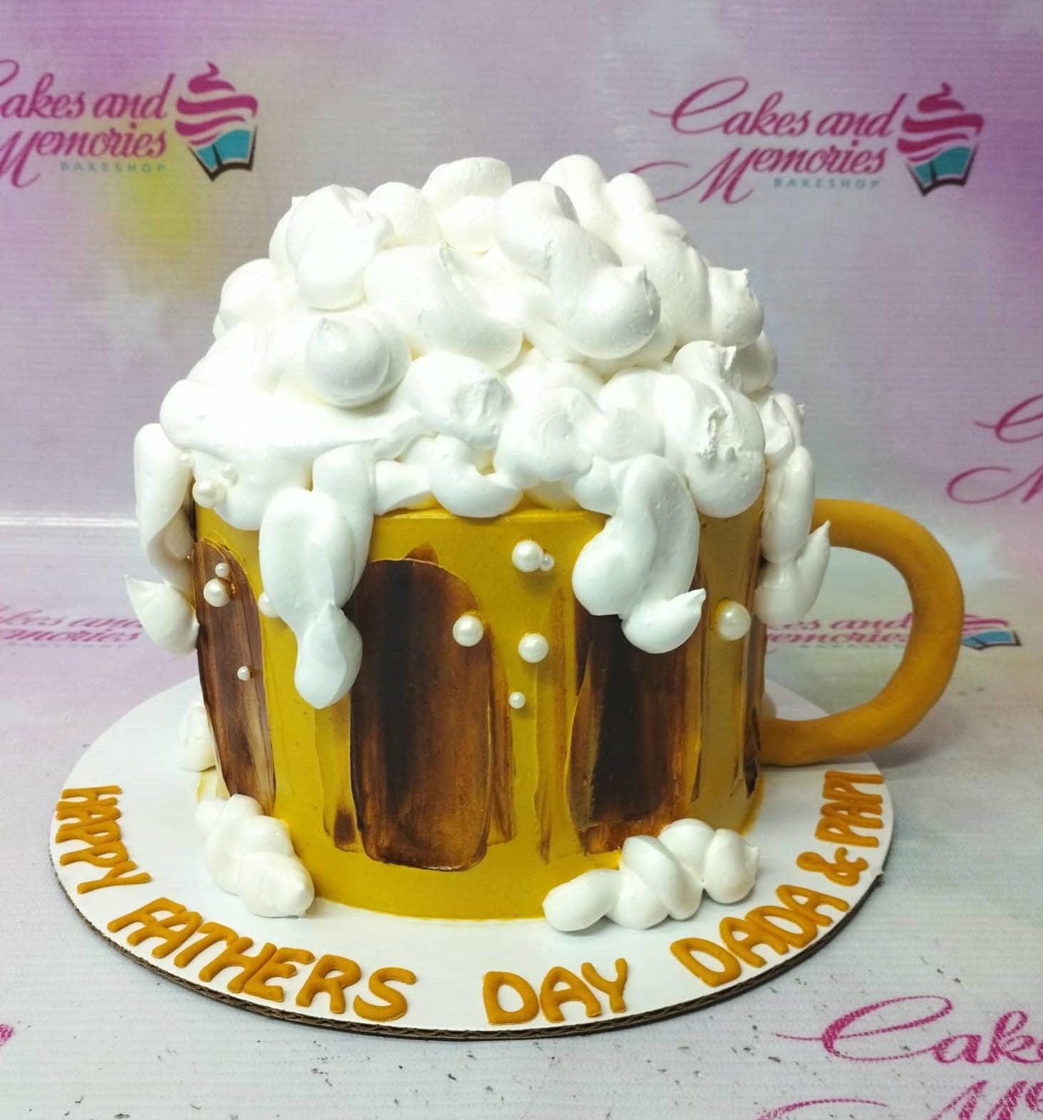 Beer mug cake with yellow icing, brown vertical panels, and white icing foam on top for Father's Day.
