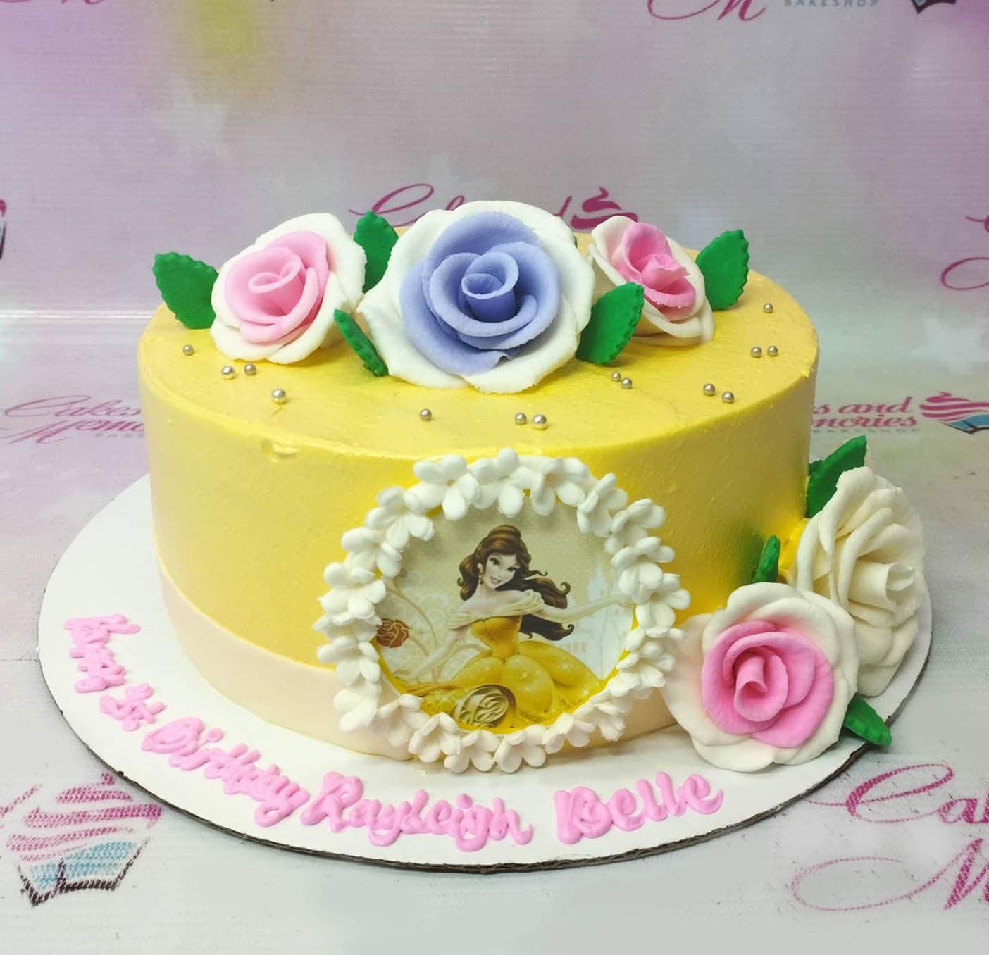 Yellow 1-tier Disney Belle princess cake with large edible fondant roses in pink, purple, and white with silver dragees.