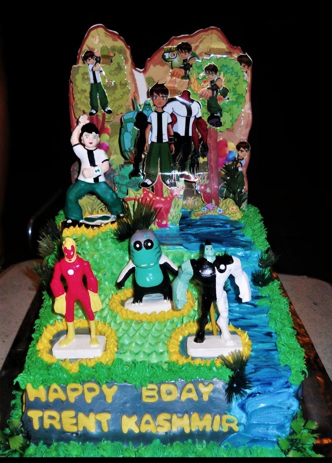 Ben 10 themed rectangle cake with green icing, a blue river design, and various character figurines and printouts.