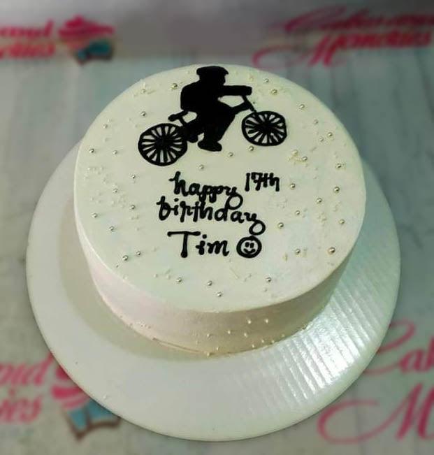 White bento cake with a black bicycle silhouette and silver dragees for Tim's 17th birthday.