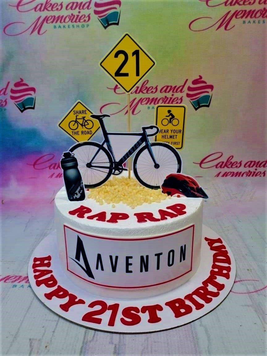 White 1-tier bicycle themed birthday cake with Aventon logo and road sign toppers