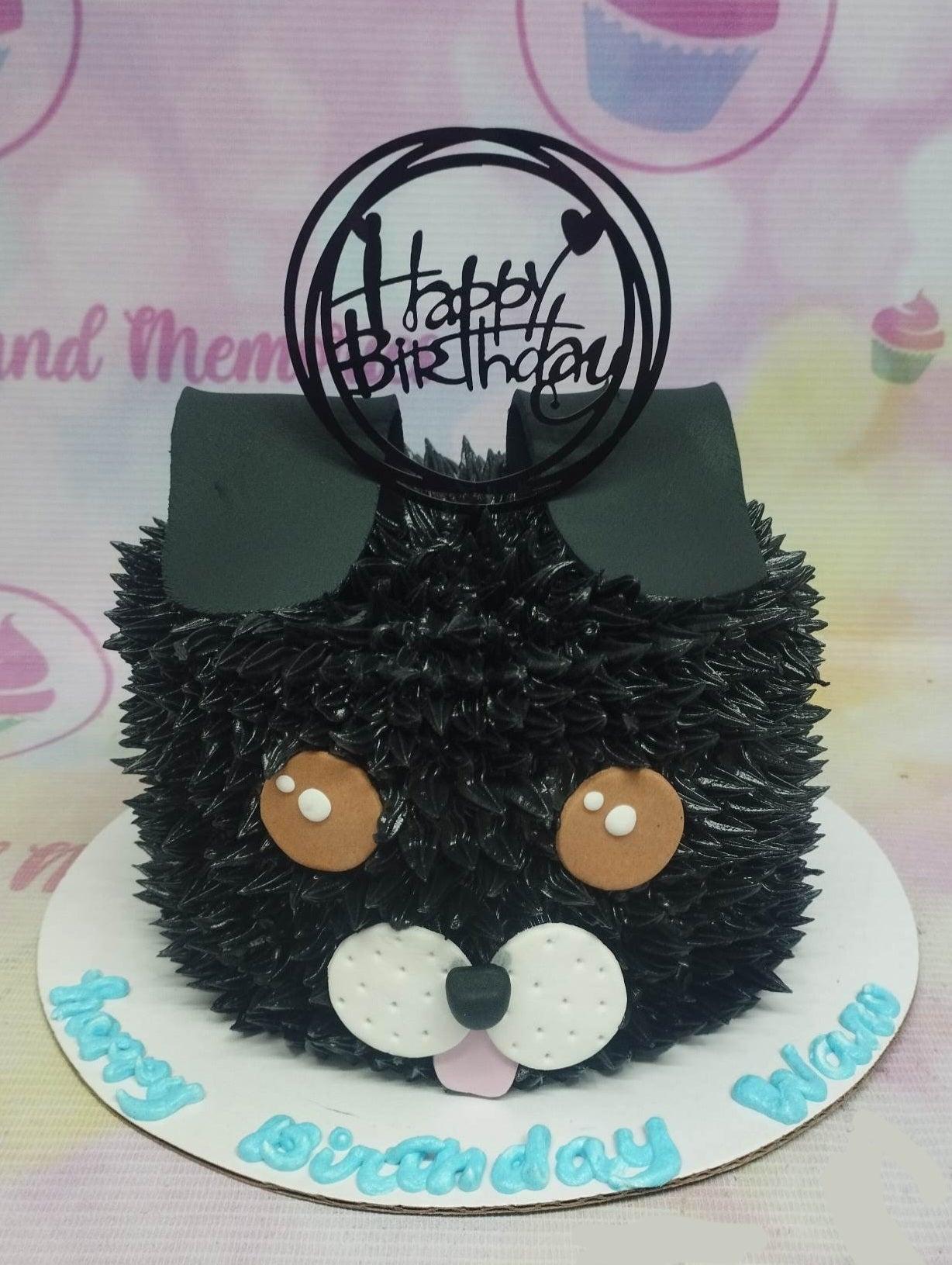 Black shaggy dog cake with black icing fur, brown fondant eyes, white muzzle, and a black Happy Birthday topper.