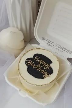 Minimalist white bento cake with a black palette knife stroke and gold Happy Birthday message in a white takeout box.