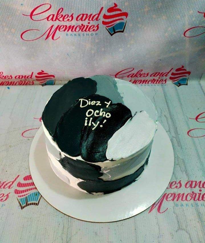 Minimalist bento cake with black, gray, and white palette knife icing strokes and a handwritten message.