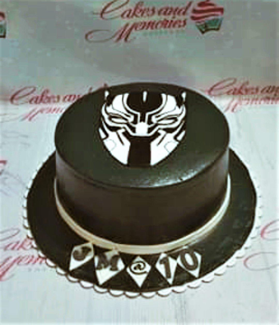 Black Panther themed birthday cake with a black icing base and a white and black character mask topper.