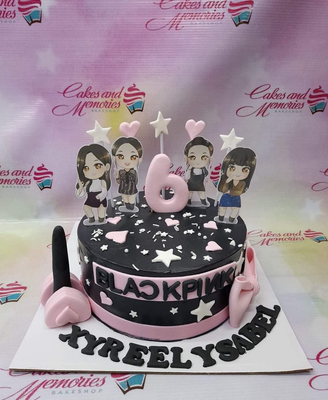Black and pink Blackpink themed cake with character printouts, a pink number 6 topper, and fondant stars and hearts.
