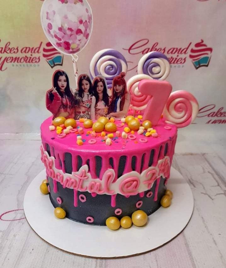 Blackpink themed birthday cake with pink drip icing, K-pop group printouts, lollipops, and a pink number 7 topper.