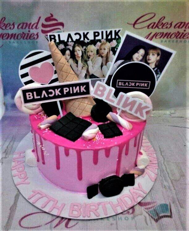 Pink Blackpink themed birthday cake with pink drip, marshmallows, chocolate bars, and printed character toppers.