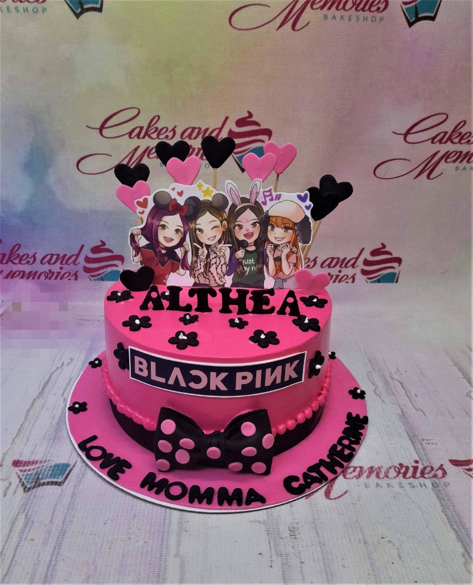 Pink Blackpink themed birthday cake for Althea with character printouts, black bow, and floral icing decorations.