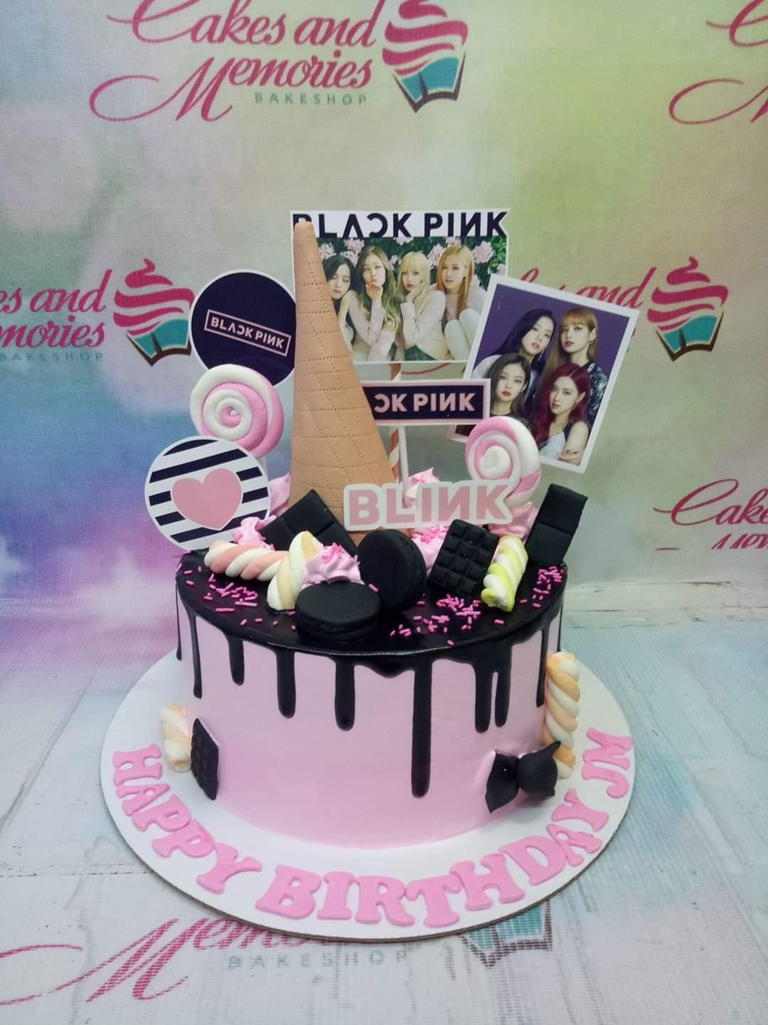Blackpink themed pink cake with black chocolate drip, macarons, marshmallows, and character printouts.