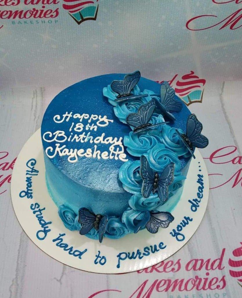 Blue gradient 18th birthday cake with blue icing rosettes and butterfly toppers