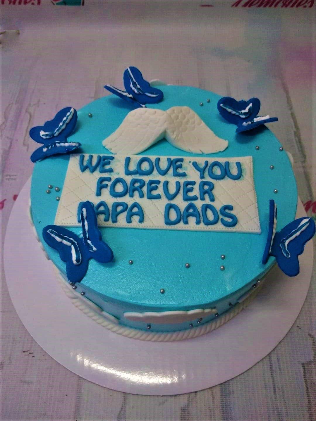 Light blue 1-tier cake with blue butterflies, white angel wings, and silver dragees for a Papa Dads celebration.