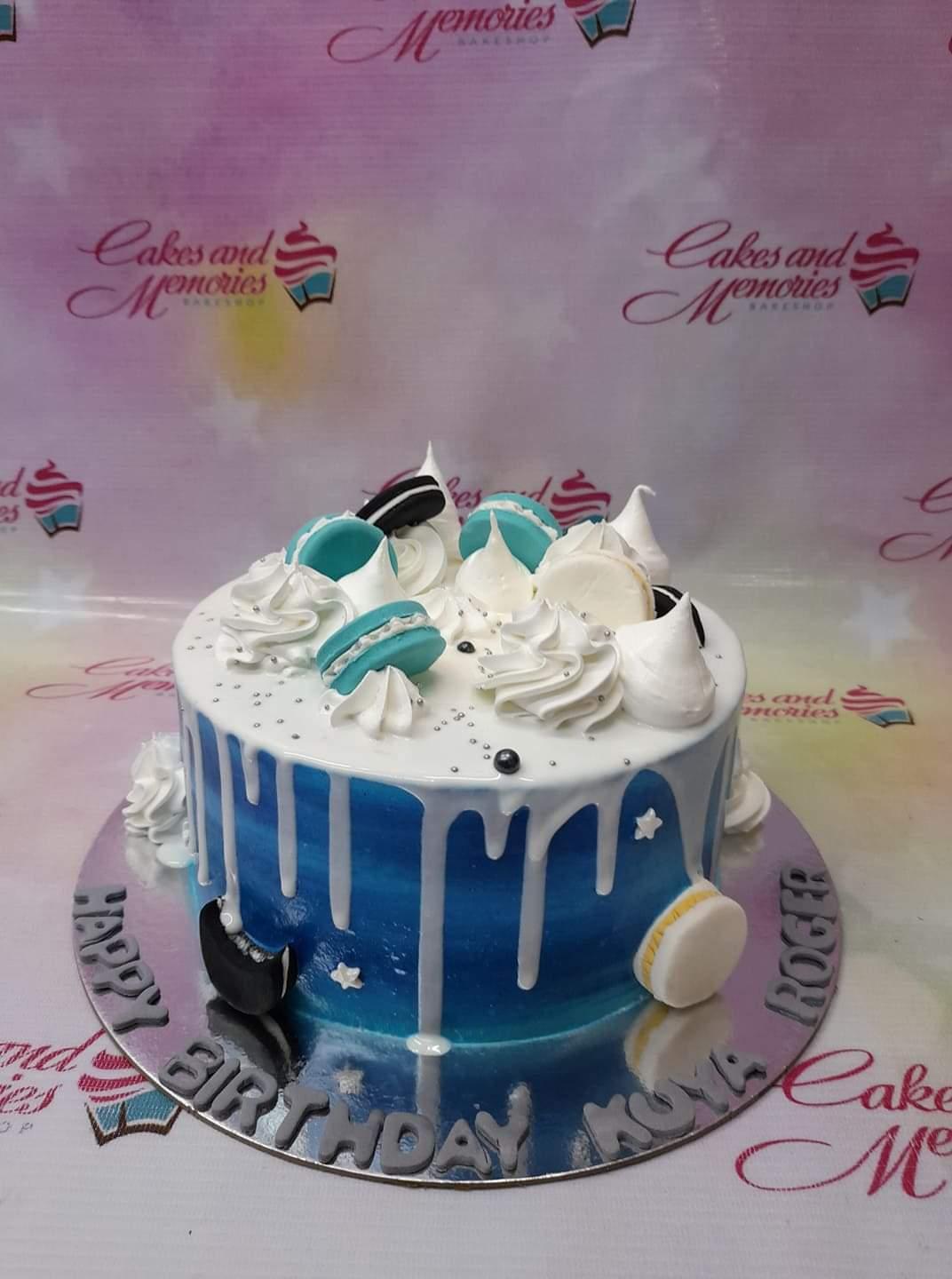 Blue and white gradient cake with white chocolate drip, macarons, and meringue kisses for Kuya Roger's birthday.