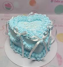 Light blue heart-shaped bento cake with intricate ruffled icing borders and white ribbon bows.