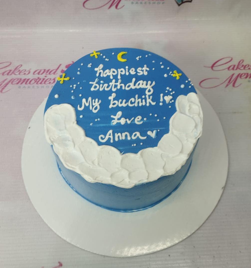 Blue bento cake with white icing clouds, yellow moon and stars, and a birthday message for Buchik.