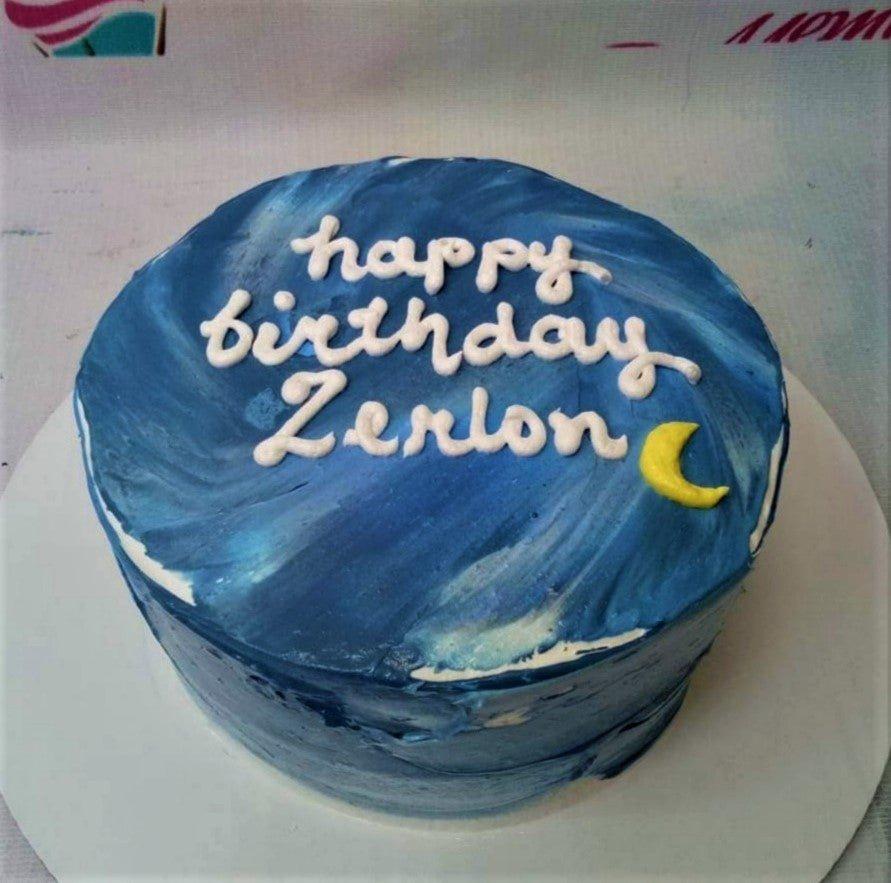Bento cake with dark blue textured icing, a yellow crescent moon, and white piped birthday message for Zerlon.