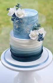 Two-tier cake with blue ombre icing and white floral decorations