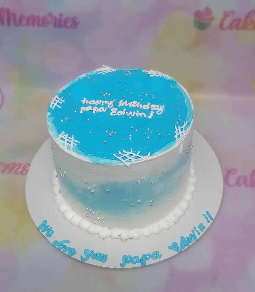 Blue and white watercolor style birthday cake with silver dragees and white icing grid patterns for Papa Edwin.