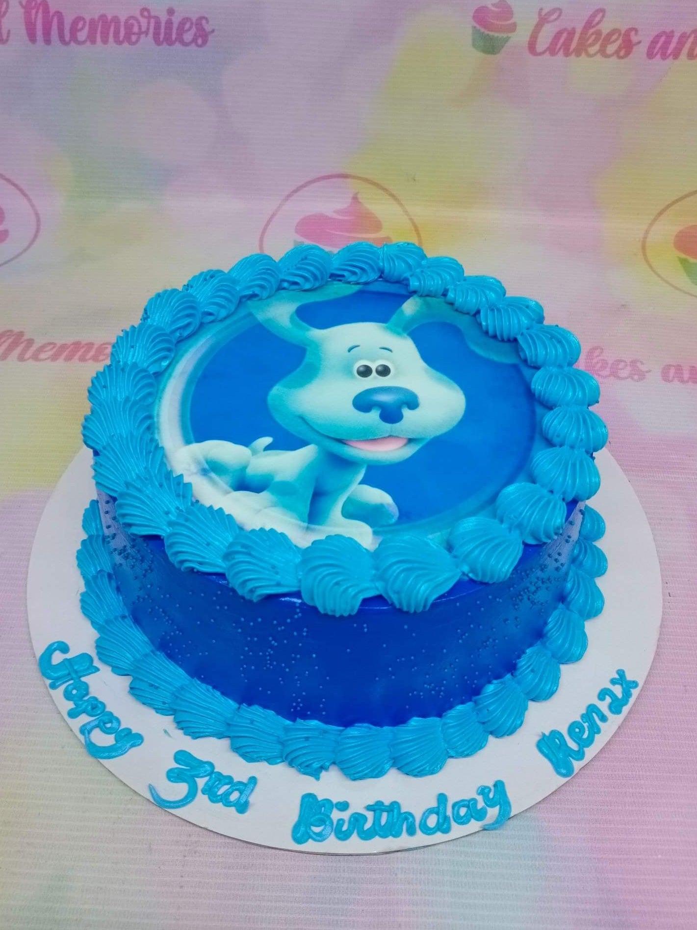 Blue's Clues themed birthday cake with a large blue dog printout on top and blue icing rosettes.
