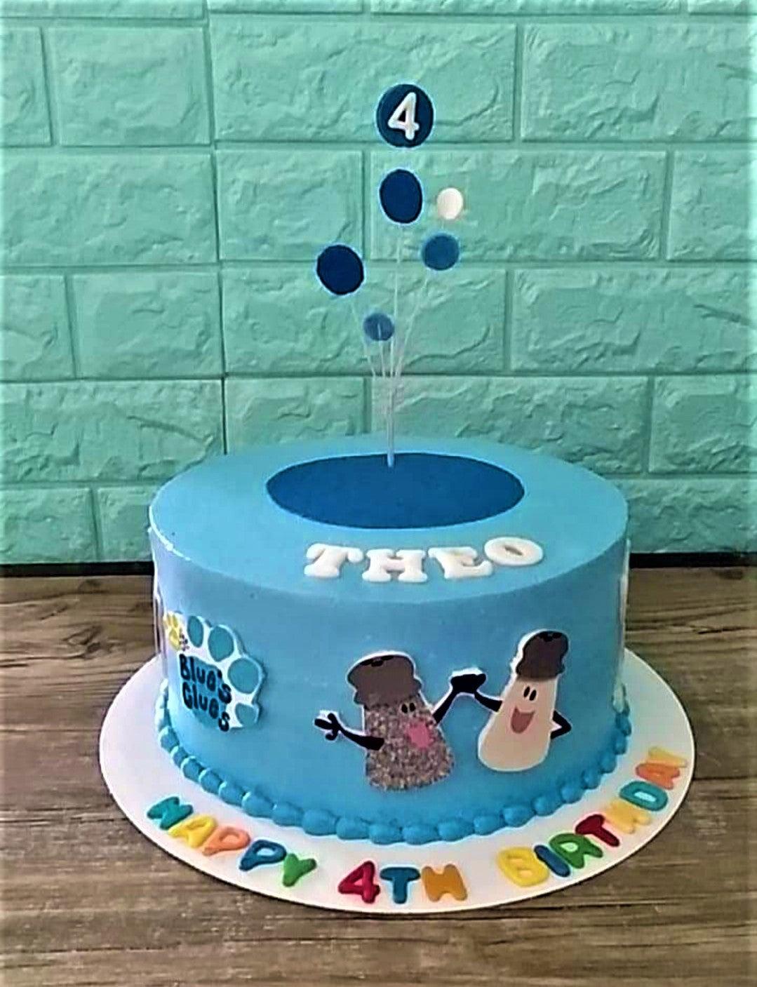 Blue's Clues themed light blue birthday cake with salt and pepper printouts and a blue balloon topper.