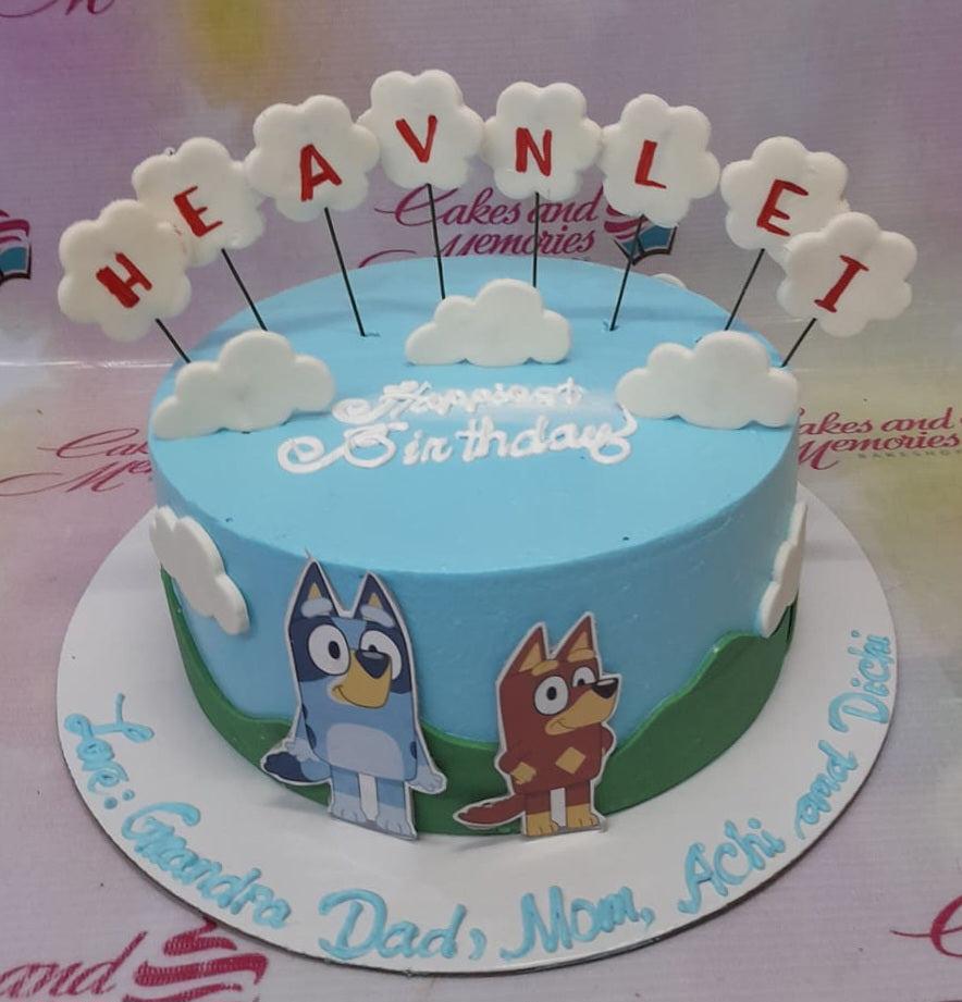 Light blue Bluey themed birthday cake with cloud toppers and character printouts on the side.
