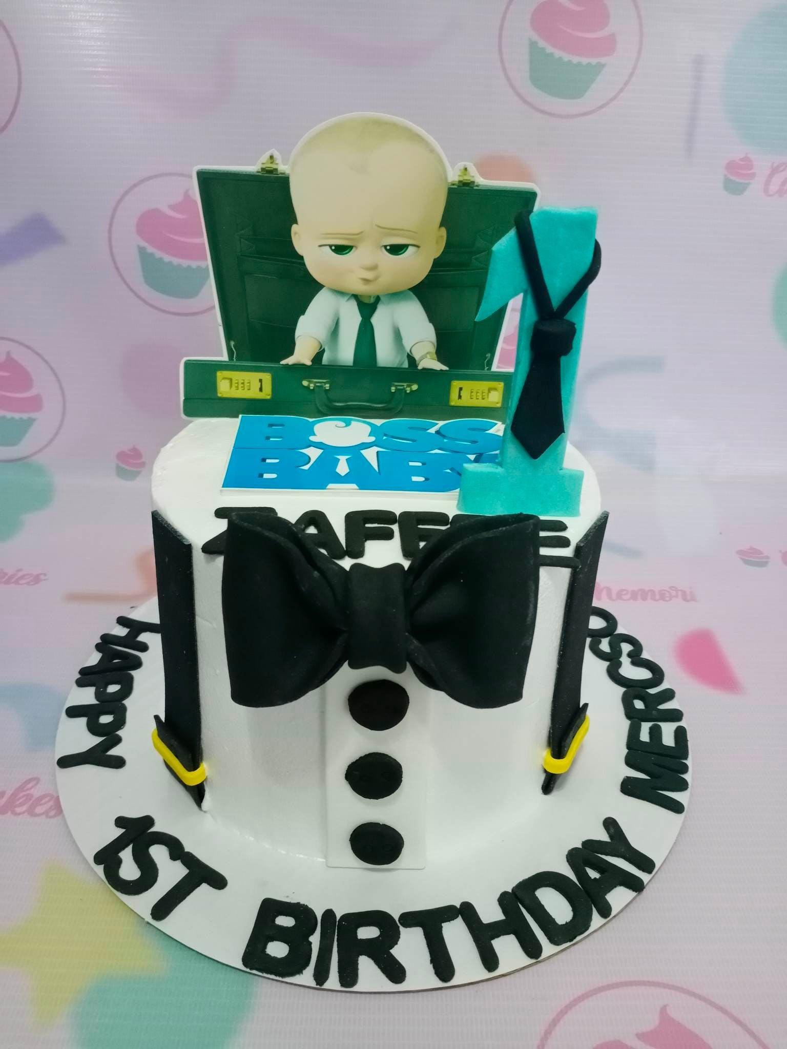 Boss Baby themed 1st birthday cake with a white tuxedo design, black bow tie, and character printouts.