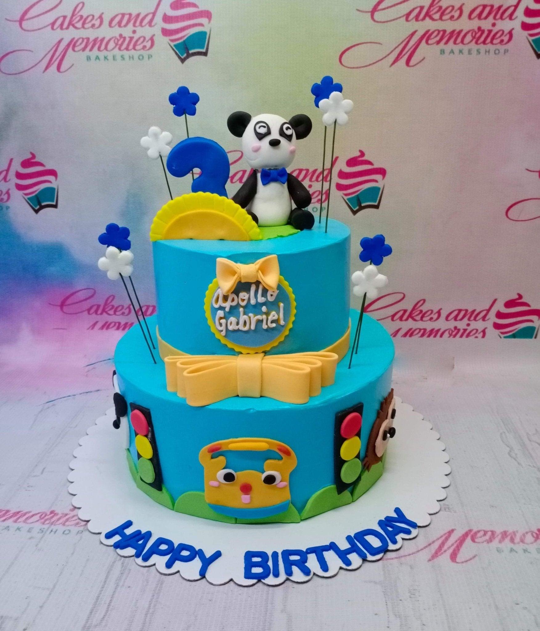 Blue 2-tier bus and panda themed birthday cake with yellow bows and traffic light decorations.