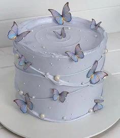 Elegant lavender purple cake decorated with delicate blue and purple butterfly printouts and white pearl sprinkles.