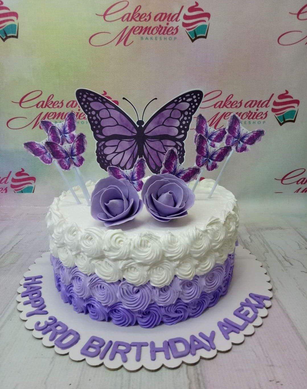 Purple and white ombre rosette cake with large purple butterfly and rose toppers for a 3rd birthday.