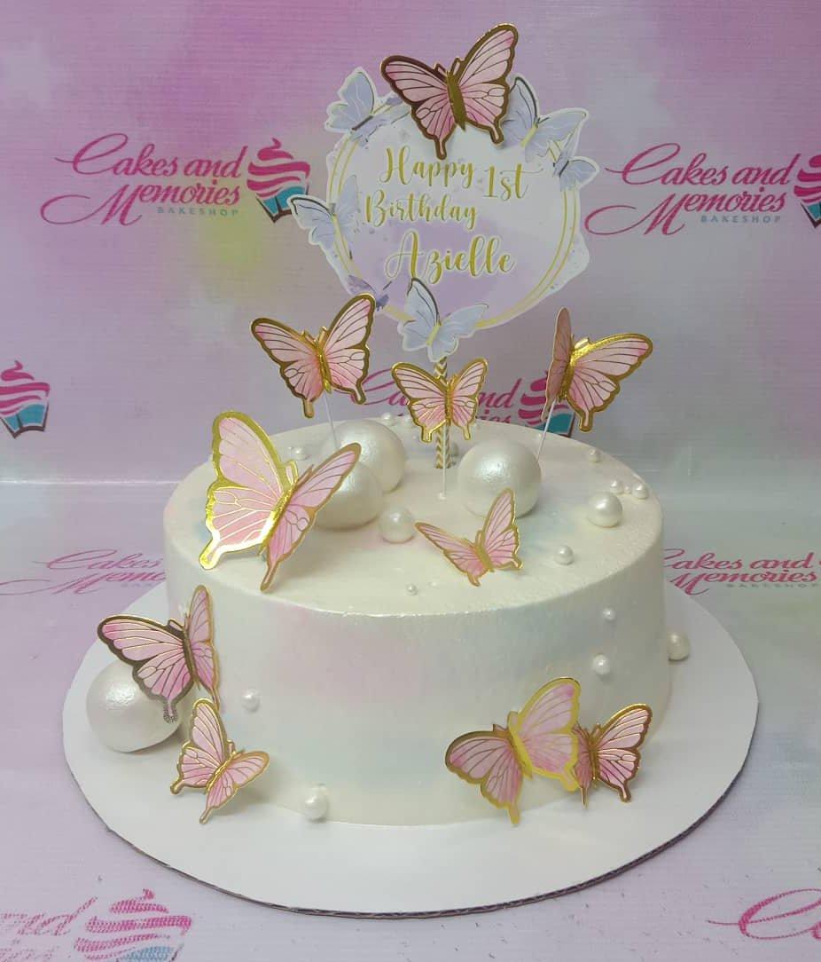 White 1-tier butterfly birthday cake with pink and gold butterfly toppers and white pearl accents.
