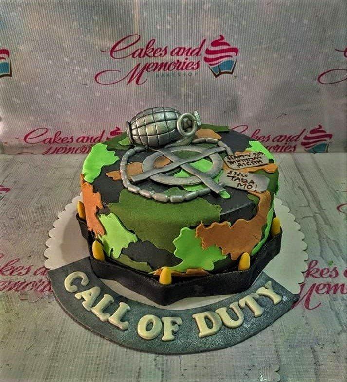 Call of Duty themed camouflage cake with a 3D fondant grenade, dog tags, and bullet accents.